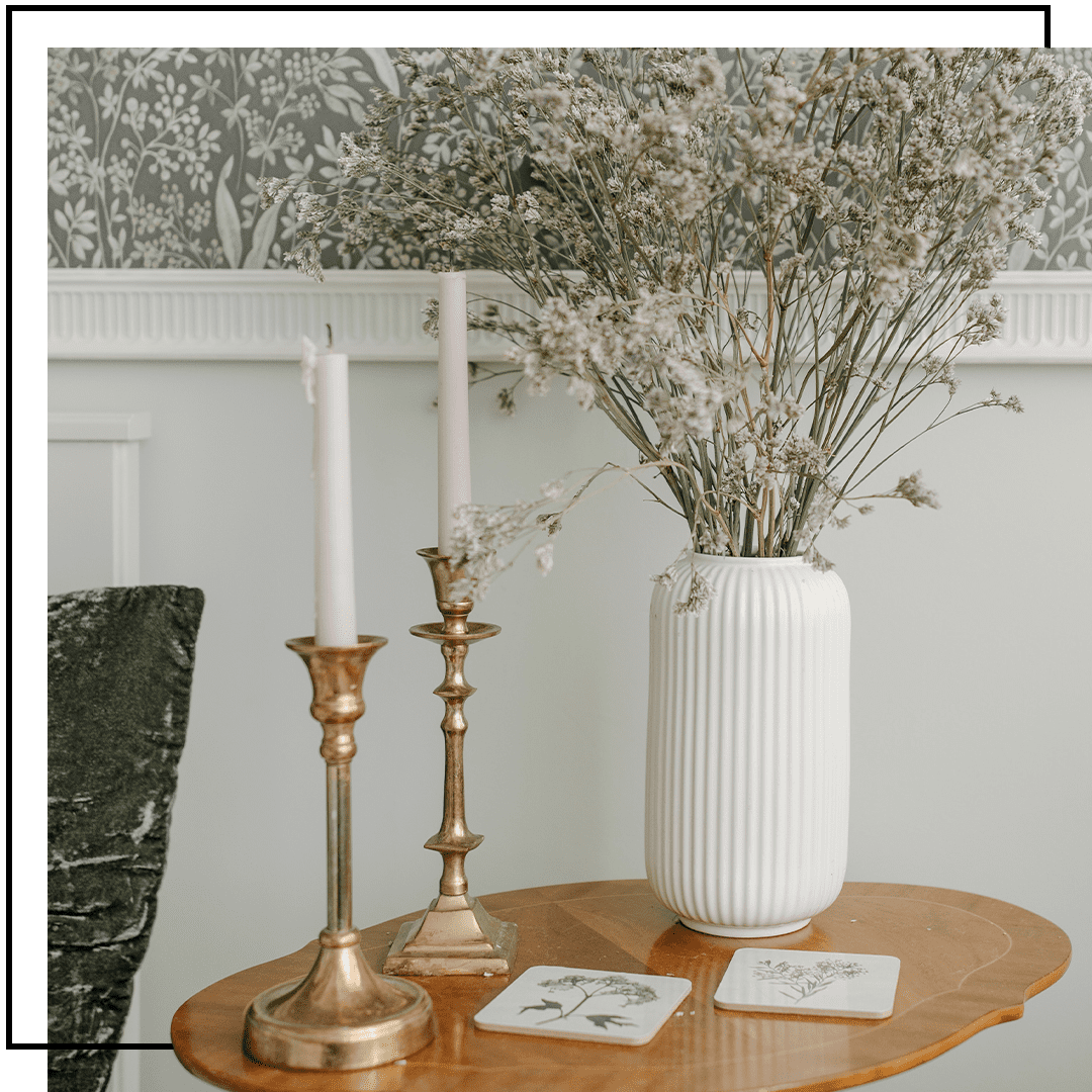 Design d’intérieur en laiton : bougeoirs en laiton sur une table basse avec un pot de fleurs moderne